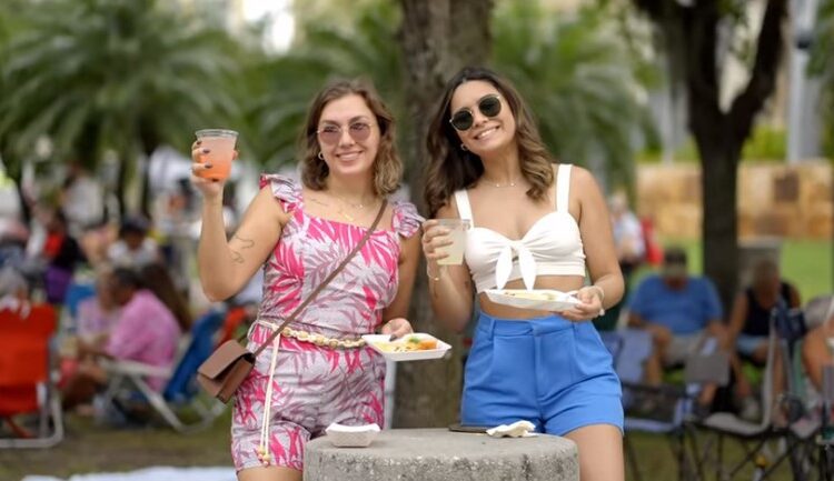 Two women attend 2024 Margarita & Taco Festival in Ave Maria and cheer with their drinks and tacos