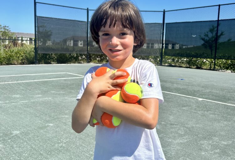 Little boy holding tennis balls 