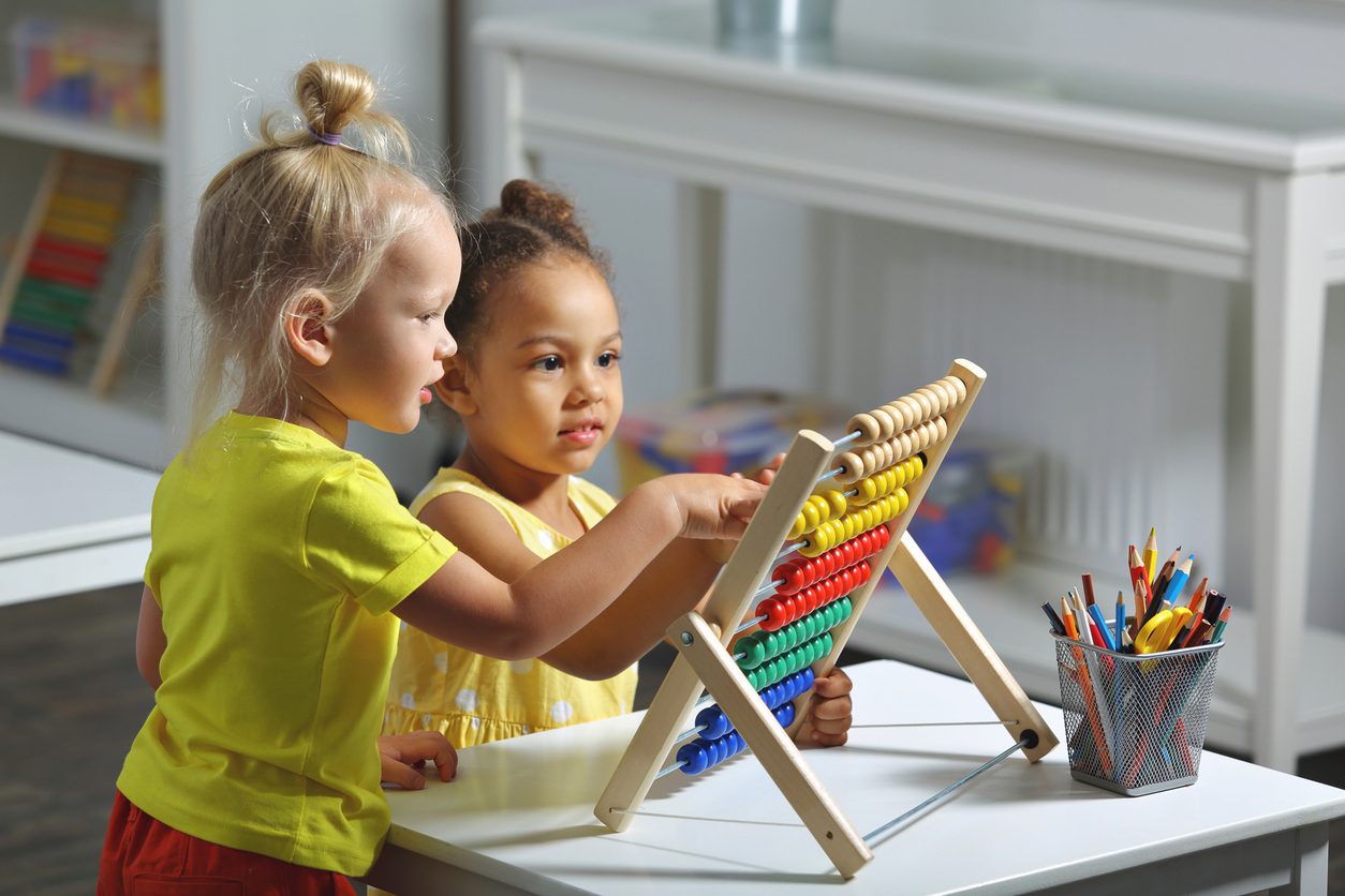 Two little girls playing with a toy