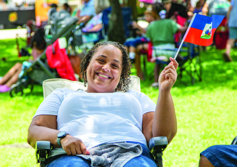 Caribbean-descent woman waves her country's flag