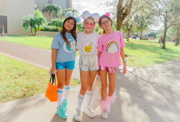 three young girls in care bear costumes