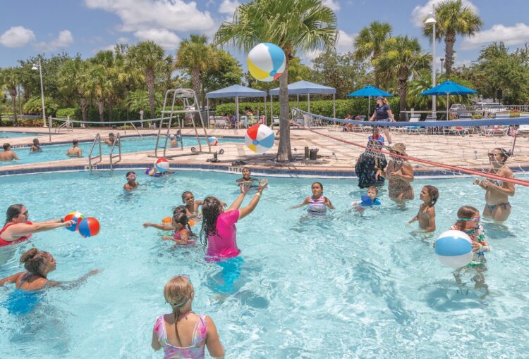 Group of people playing volleyball in the water park 