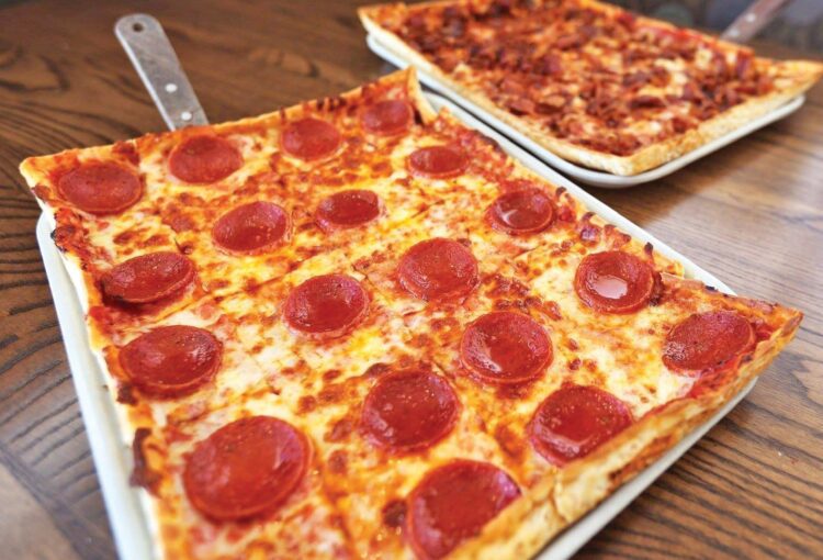 two fresh pizzas on the pans