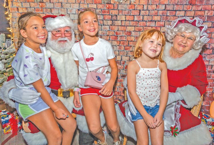 three girls sitting with Mr. and Mrs. Claus 