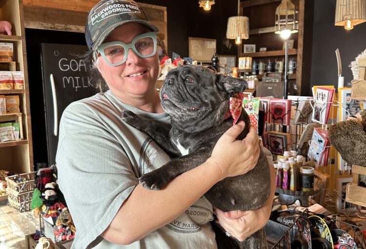 Misty McWilliams, owner of Backwoods Feed with dog