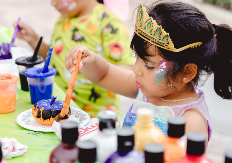 Girl paints a pumpkin