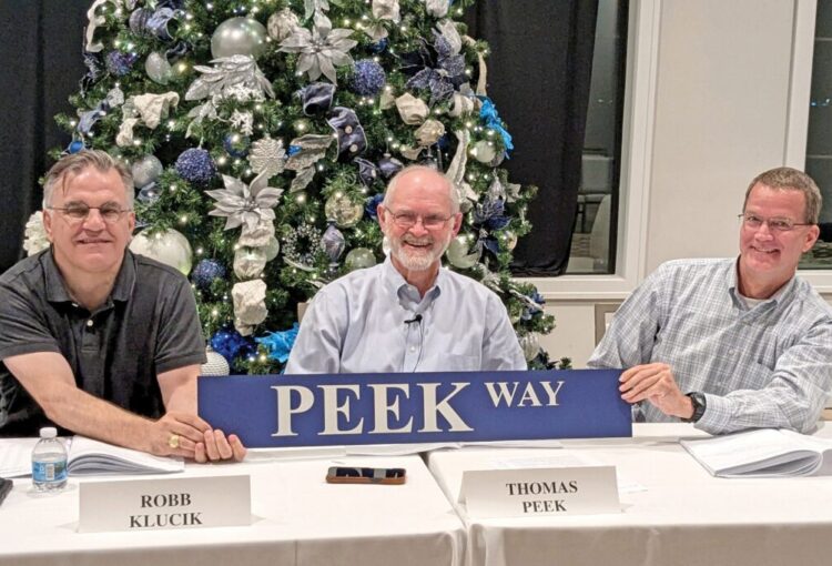 Thomas Peek, longtime chairman of the Ave Maria Board of Supervisors, is honored with a road sign renaming Massa Way to Peek Way.