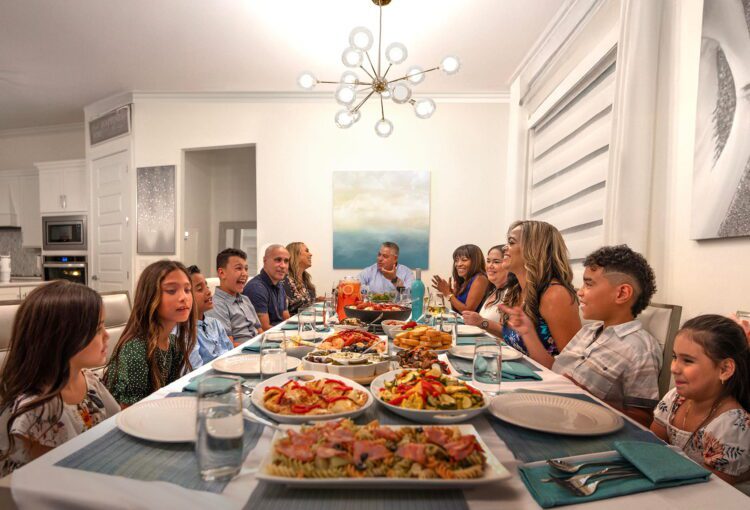 Large family gathers around table for dinner