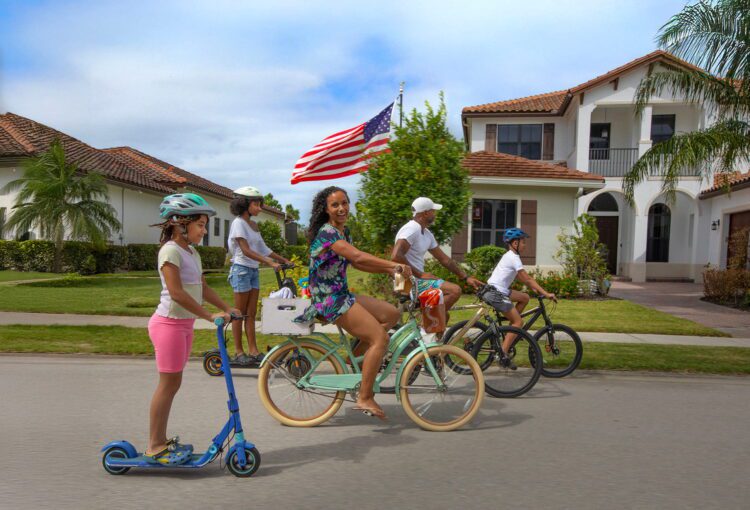 Family rides their bikes on their neighborhood street